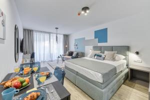 une chambre d'hôtel avec un lit et une table avec de la nourriture dans l'établissement Apartments Hica, à Dubrovnik