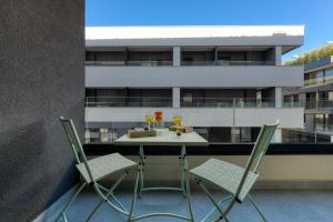 un tavolo e sedie su un balcone con bicchieri da vino di Apartments Hica a Dubrovnik
