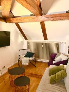 een woonkamer met een bank en stoelen en een tv bij Ferienwohnung Nepomuk in Landshut