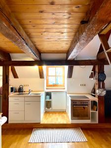 cocina con electrodomésticos blancos y techo de madera en Ferienwohnung Nepomuk, en Landshut