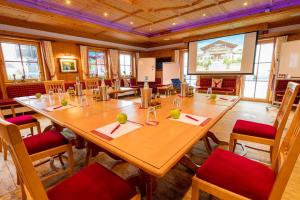 Steig-Alm Hotel Superior في باد مارينبرغ: قاعة اجتماعات مع طاولة وكراسي خشبية كبيرة
