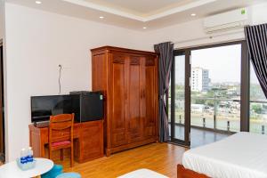 a living room with a tv and a bed at Khách sạn Ngọc Hồi in Quy Nhon
