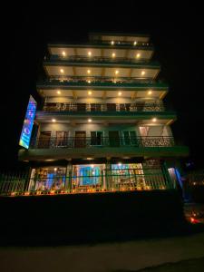 een hoog gebouw met 's nachts verlichting bij Mingo Guest House in Pokhara
