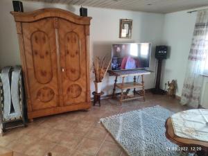 a living room with a large wooden cabinet and a tv at Ferienwohnung Mitwitz Kronach Neustadt Coburg - Erholung, Wandern uvm. sehr ruhig gelegen in Mitwitz