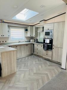 a large kitchen with wooden cabinets and a skylight at Brackencroft Lodge with Hot Tub in York