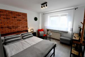 a bedroom with a large bed and a brick wall at Apartament - Spytkowice in Spytkowice