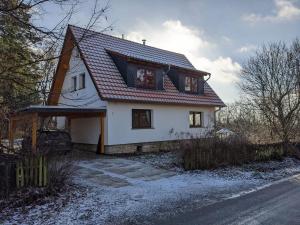 a white house with a red roof in the snow at Ahlberg Ferienhaus in Mariendorf