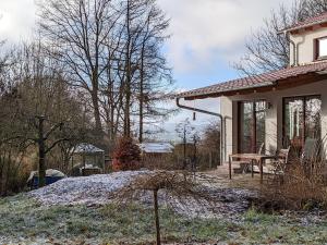 a house with snow on the ground next to a table at Ahlberg Ferienhaus in Mariendorf