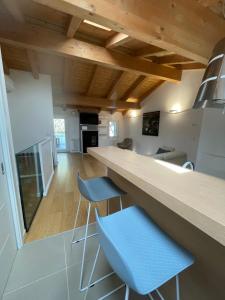 a kitchen with a counter and two blue stools at Casa Calle Pescheria in Grado +13 photos