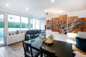 a living room with a dining room table and a tree painting at Quartier Bergzeit 1 in Stryck