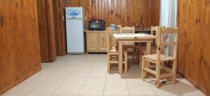 eine Küche mit einem Tisch und einem Kühlschrank in der Unterkunft Complejo cabañas el paraje in Ranchos