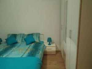 ein Schlafzimmer mit einem blauen Bett und einem Nachttisch in der Unterkunft Ugljanski gusari in Ugljan