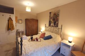 a bedroom with a bed with a tray of food on it at The Corner House - Historic Character Cottage in the Forest in Coleford