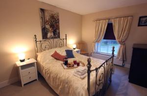 a bedroom with a bed with a tray of food on it at The Corner House - Historic Character Cottage in the Forest in Coleford