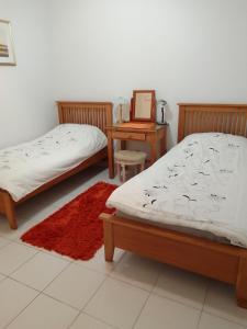 two beds in a room with a table and a chair at Aphrodite Springs in Paphos City