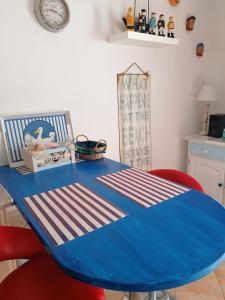 Fisherman s Cove في كوستا كالما: طاولة زرقاء في مطبخ مع كراسي حمراء