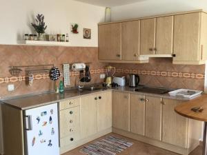 a kitchen with wooden cabinets and a white refrigerator at Fisherman s Cove in Costa Calma