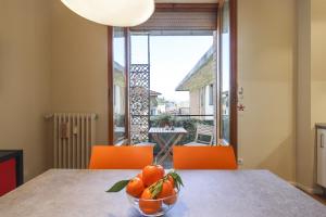 un bol d'oranges sur une table avec des chaises orange dans l'établissement Dalla Giulia - A/C, Wi-Fi, Private Parking - Sweet Dreams in Florence, à Florence