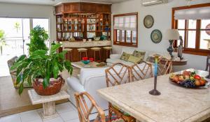 ein Wohnzimmer mit einem Sofa und einem Tisch in der Unterkunft Casa beira mar na Praia da Enseada no Guaruja SP in Guarujá