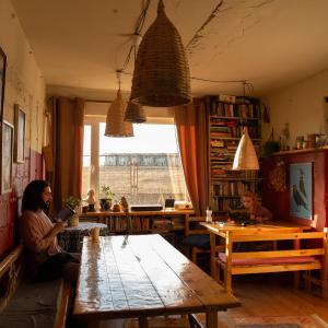 Eine Frau, die an einem Tisch in einem Zimmer sitzt. in der Unterkunft Udabno Hostel in Udabno