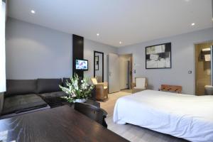 um quarto de hotel com uma cama e um sofá em Logis Cottage Hotel em Vandoeuvre-lès-Nancy