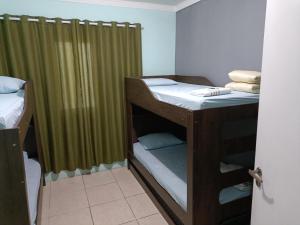 Zimmer mit 2 Etagenbetten und einer Dusche in der Unterkunft 10 MIN AEROPORTO GUARULHOS in Guarulhos