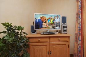 a flat screen tv sitting on top of a wooden cabinet at Meeresblick Wohnung 215 in Kühlungsborn