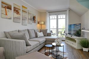 ein Wohnzimmer mit einem Sofa und einem TV in der Unterkunft Villa Hanse Wohnung 320 in Kühlungsborn