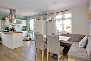 Villa Hanse Wohnung 320 في كولونغسبورن: مطبخ وغرفة معيشة مع أريكة وطاولة