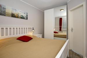 1 dormitorio con 1 cama grande y espejo en Meeresblick Wohnung 112, en Kühlungsborn