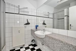 Baño blanco con lavabo y espejo en Meeresblick Wohnung 112, en Kühlungsborn