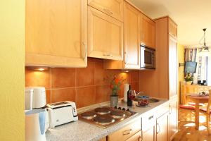 eine Küche mit Holzschränken und einer Arbeitsplatte in der Unterkunft Meeresblick Wohnung 408 in Kühlungsborn