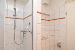 eine Dusche im Bad mit weißen Fliesen in der Unterkunft Meeresblick Wohnung 408 in Kühlungsborn + 19 Fotos