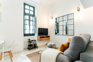a living room with a couch and a tv at Modern and wide- 1Bd 1Bth- Triana in Seville