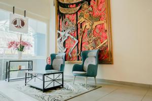 two chairs and a table in a room with a painting at EDC Hotel Kuala Lumpur in Kuala Lumpur