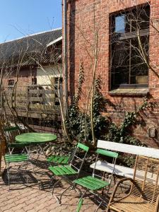 a group of chairs and a bench in front of a brick building at Spurensucher Quartier in Usedom Town