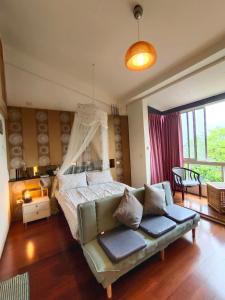 1 dormitorio con cama y sofá en Miaoli Sanyi Travelling Homestay en Sanyi