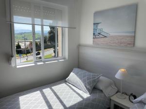 1 dormitorio con cama y ventana grande en Apartamento Excelentes vistas a la Ria, Wifi y Parking, en San Vicente de la Barquera