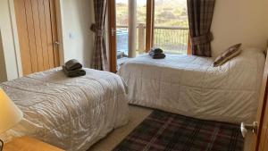a bedroom with two beds and a window at Waterloo House in Lochinver