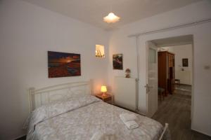 a bedroom with a bed and a lamp on a table at Lorentzia House 2 ! in Apróvaton