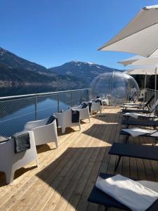 a deck of a boat with white chairs and water at Kantor Village am Millstätter See - Boutique-Chalets und Lodges in Millstatt