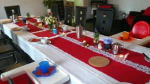 a long table with a red and white table cloth at Pension-Mummerliese in Goseck