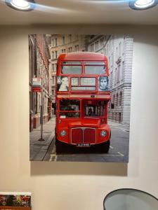 a red double decker bus on a city street at SureScape House in Liverpool