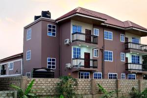 a large purple building with a fence in front of it at Comfy & Cozy Hideout Close to Highway Parking in Pantang