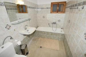 a bathroom with a tub and a sink and a bath tub at Villa Erika Mountain Escape in Áno Vlasía