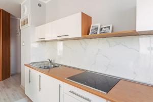 a kitchen with white cabinets and a sink at CHILLIapartamenty - Portowa - SAILOR in Kołobrzeg