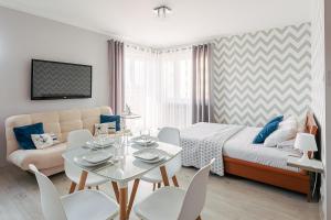 a bedroom with a bed and a table and chairs at CHILLIapartamenty - Portowa - SAILOR in Kołobrzeg