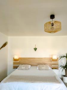 1 dormitorio con 1 cama blanca grande y 2 almohadas en Émeraude, en Penmarch