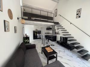 a living room with a couch and a staircase at Gîtes dans Mas en pierres in Robion en Luberon