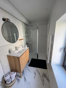une salle de bains blanche avec un lavabo et un miroir dans l'établissement Gîtes dans Mas en pierres, à Robion